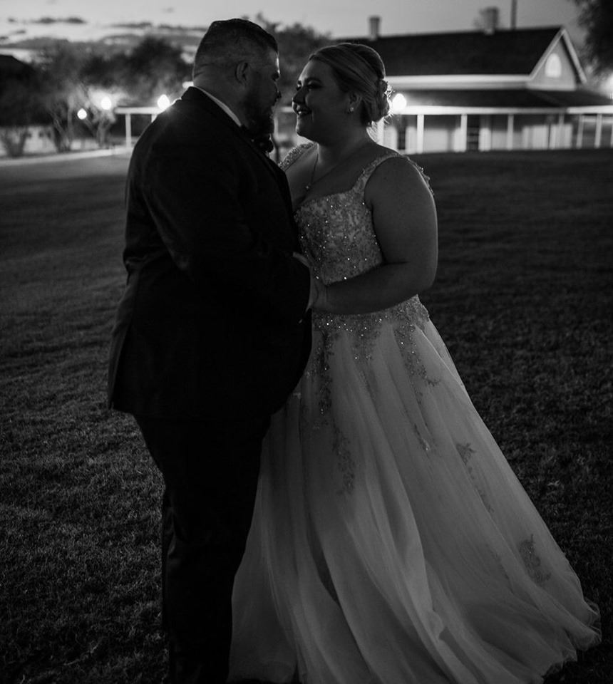 Bride in white wedding dress is staring at groom. Grayscale