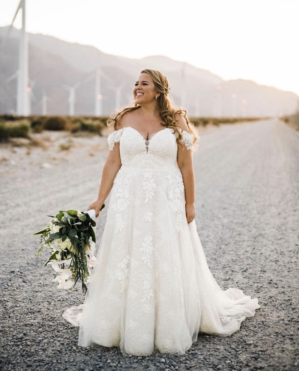 Blonde bride in white dress at country road