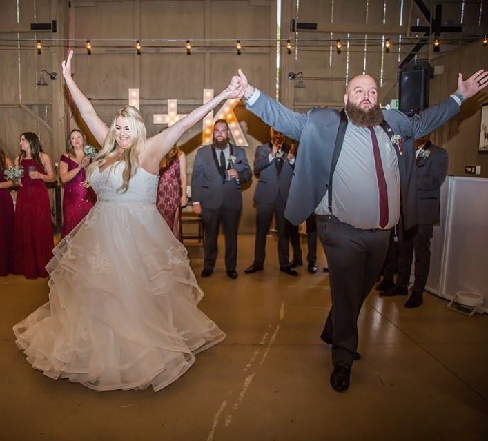 Blonde bride in white wedding dress walks with groom